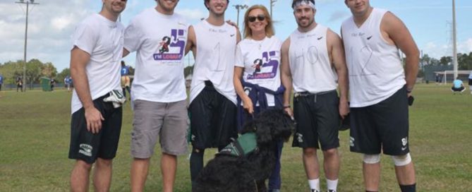 Five men with I’m Logan It founder P.A. Kushner and her service dog.