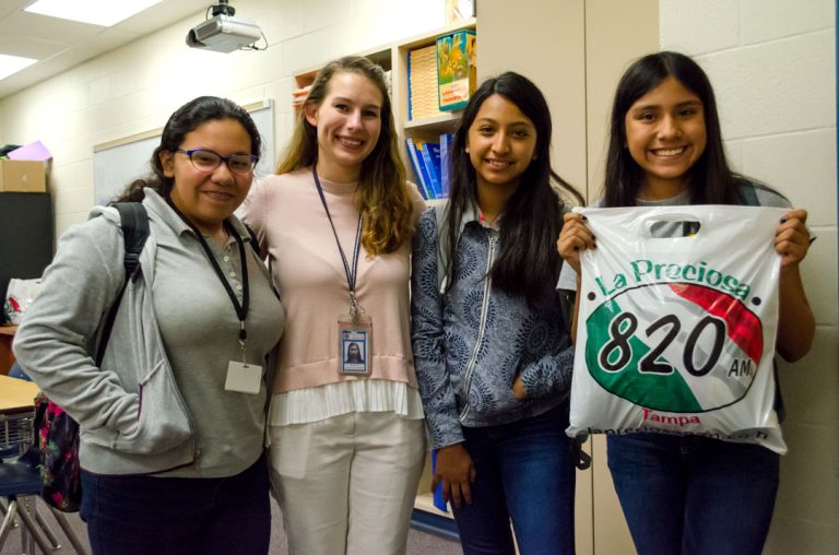 Four young women showing #TacoSquad food bag.
