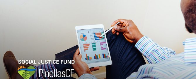 A Black businessman looks at graphs on his tablet.