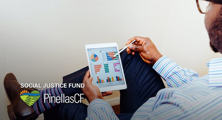 A Black businessman looks at graphs on his tablet.
