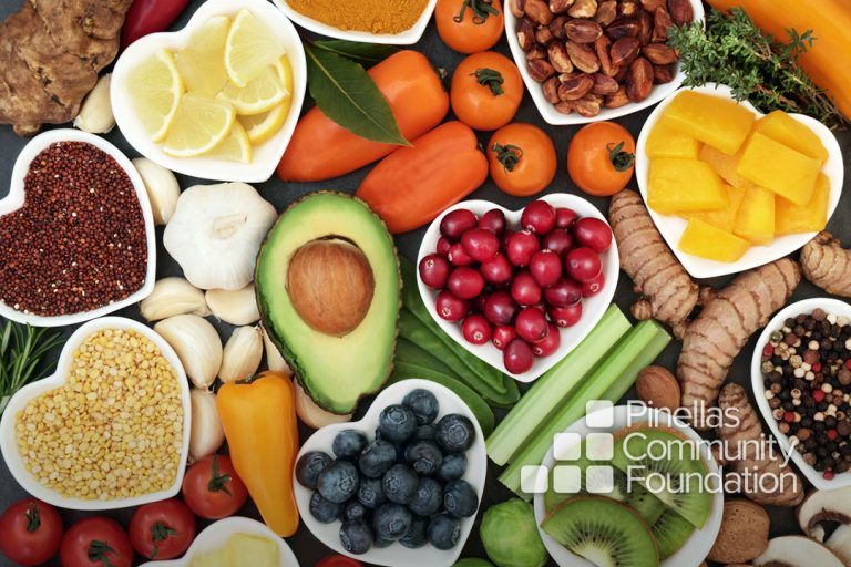 Fruits, vegetables laid out on counter top, heart shaped bowls.