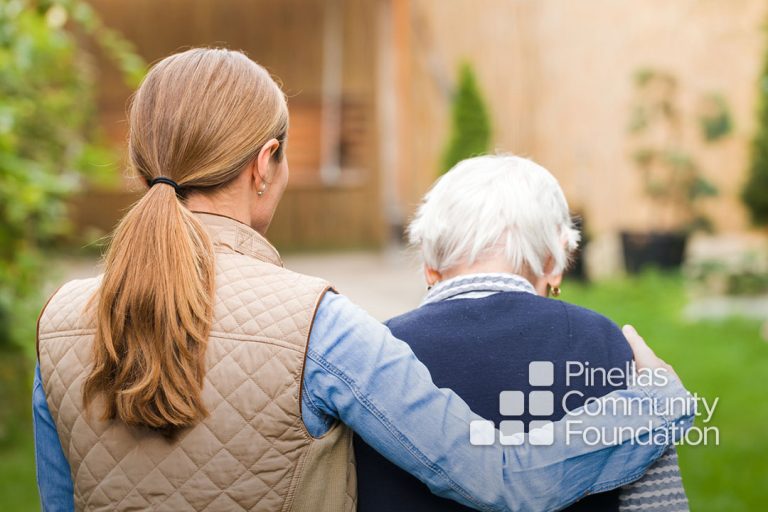 Caregiver walking with dementia patient.