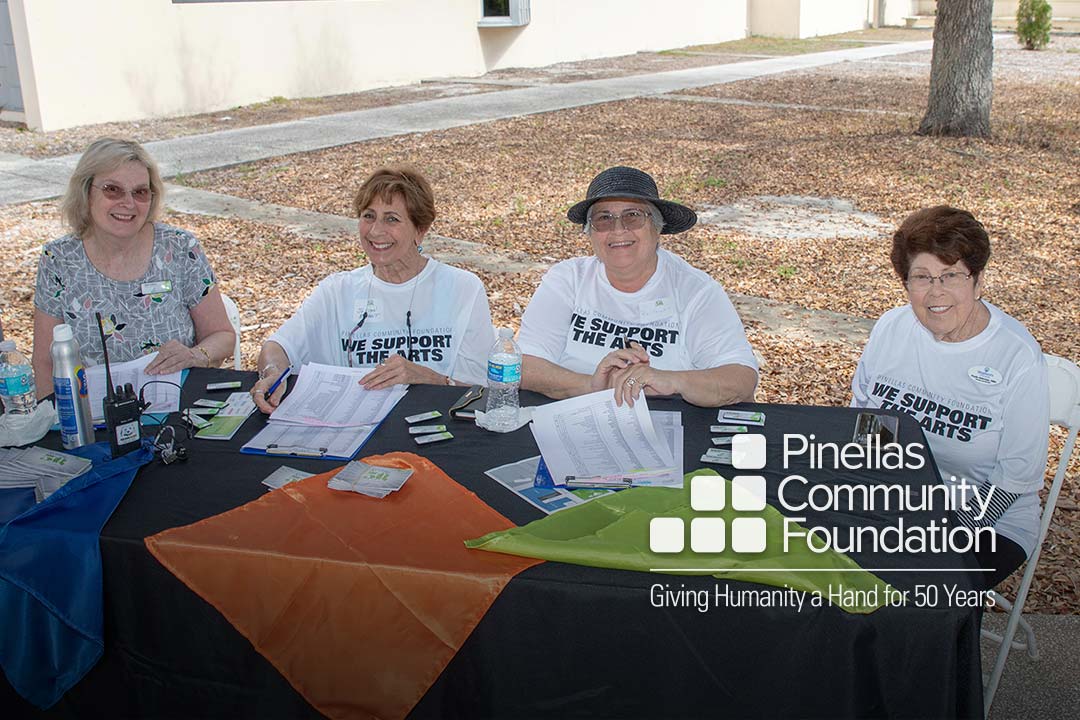 Happy, smiling volunteers at Festivale 50 registration table
