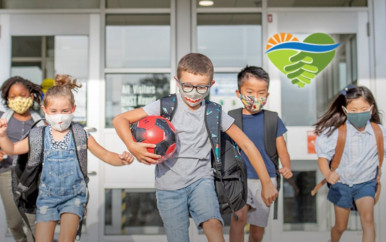 Children wearing colorful masks running out of school to recess.