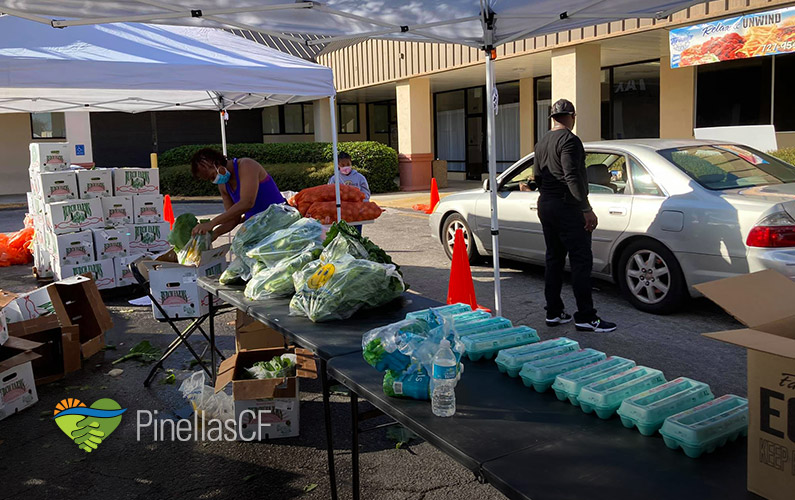 Advantage Village Academy workers load groceries in trunks at the drive-thru pantry.