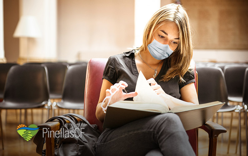 A college student wearing a mask studies law in the library.