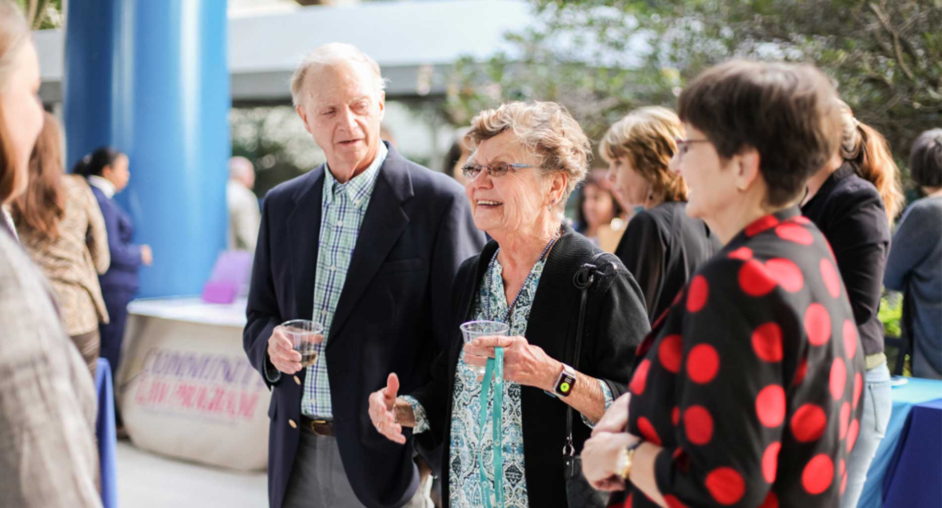 Donors talking and smiling at an outdoor Pinellas Community Foundation event.